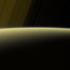 Dūmaka pie Saturna horizonta un gredzeni fonā
